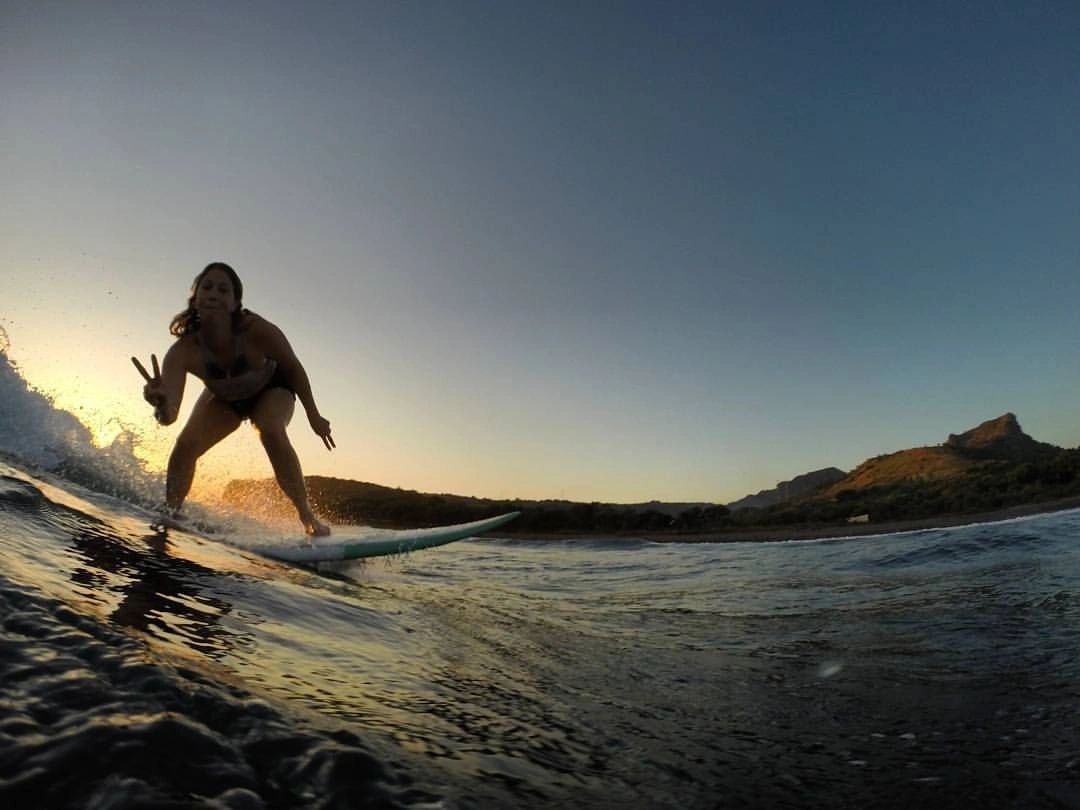 Jo-Roxy surfing a small wave at sunset